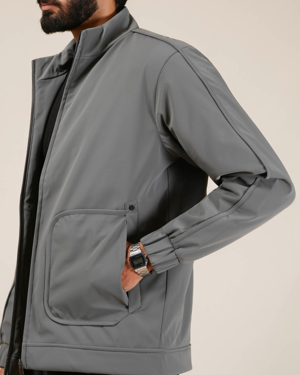 Gray jacket worn by a person on a beige background