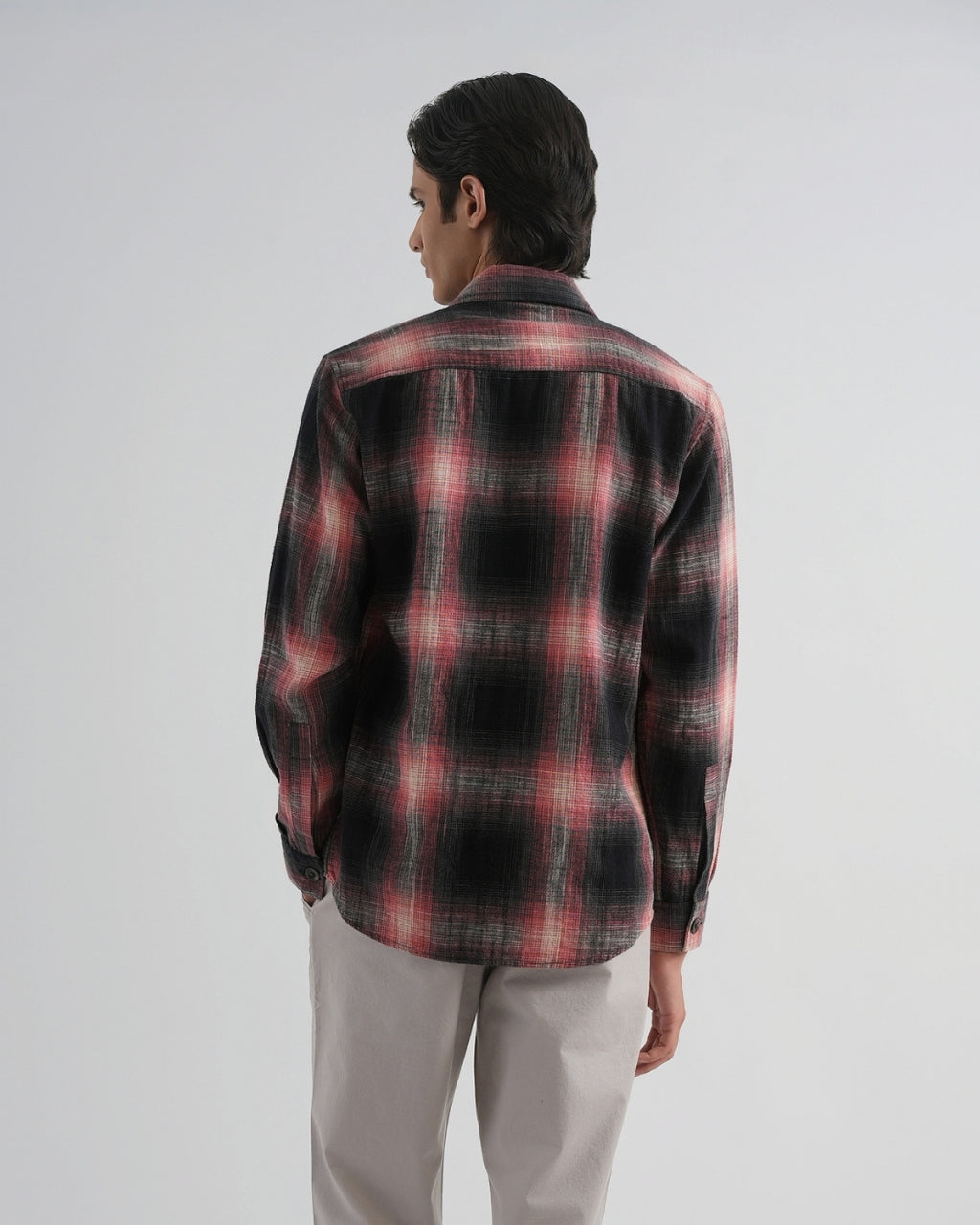 Person wearing a red and black plaid shirt on a white background