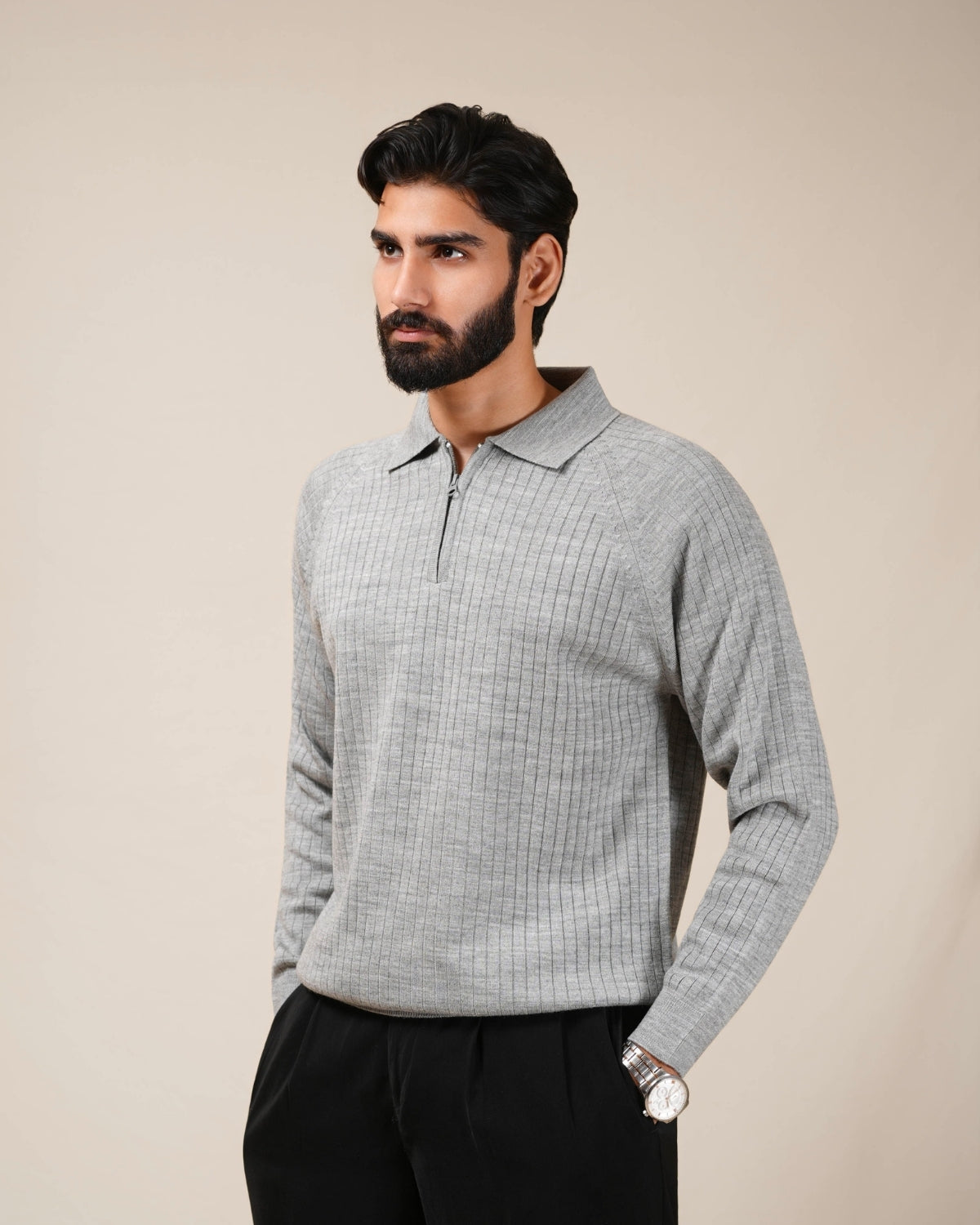 Man wearing a gray checkered long-sleeve shirt against a beige background