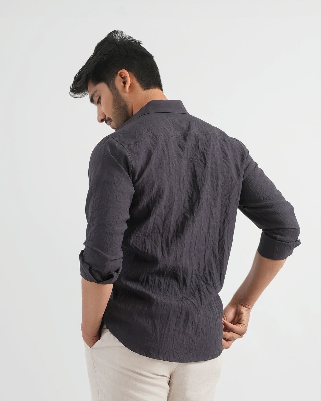 Man wearing a dark gray textured shirt on a white background