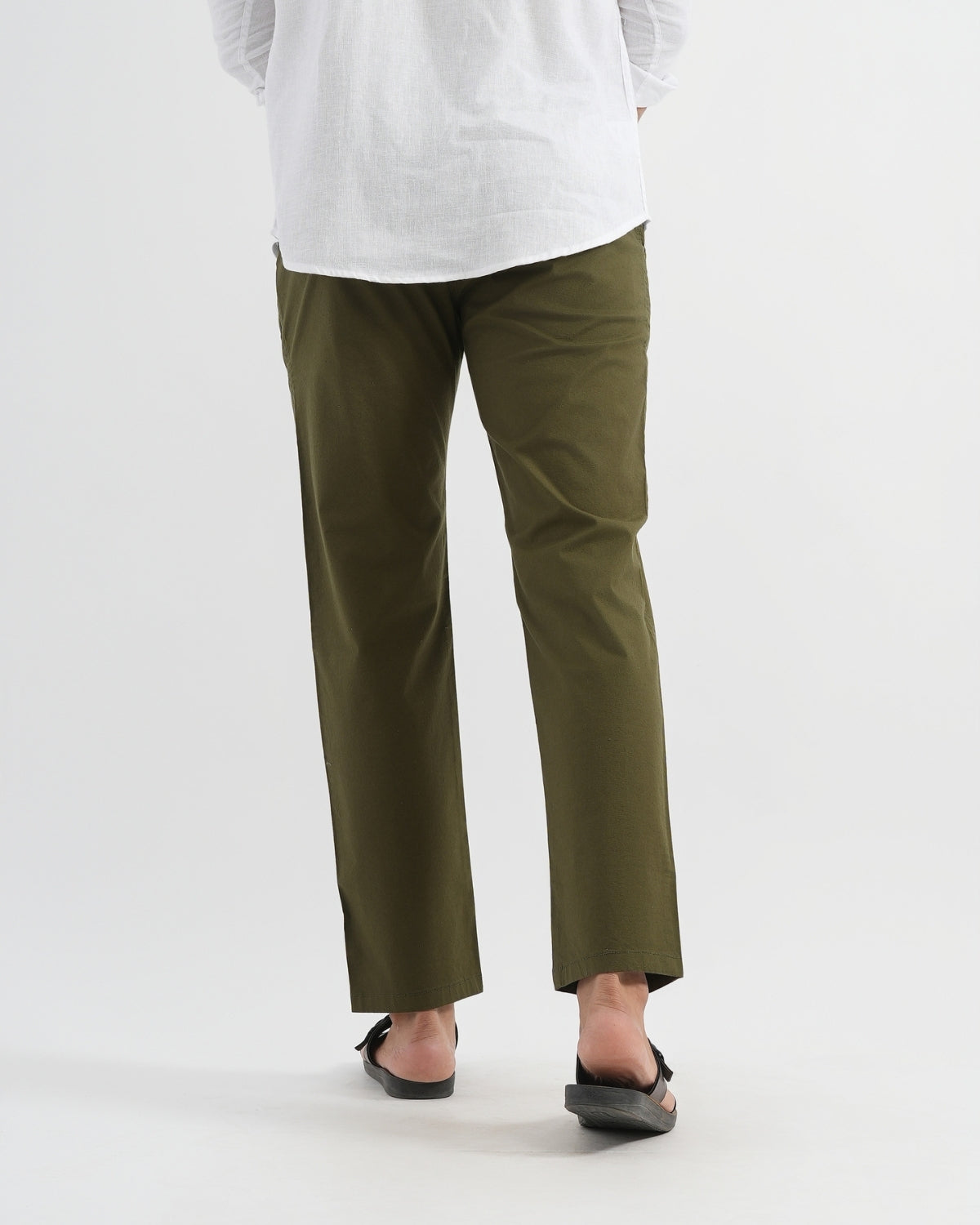 Person wearing olive green pants and a white shirt on a white background