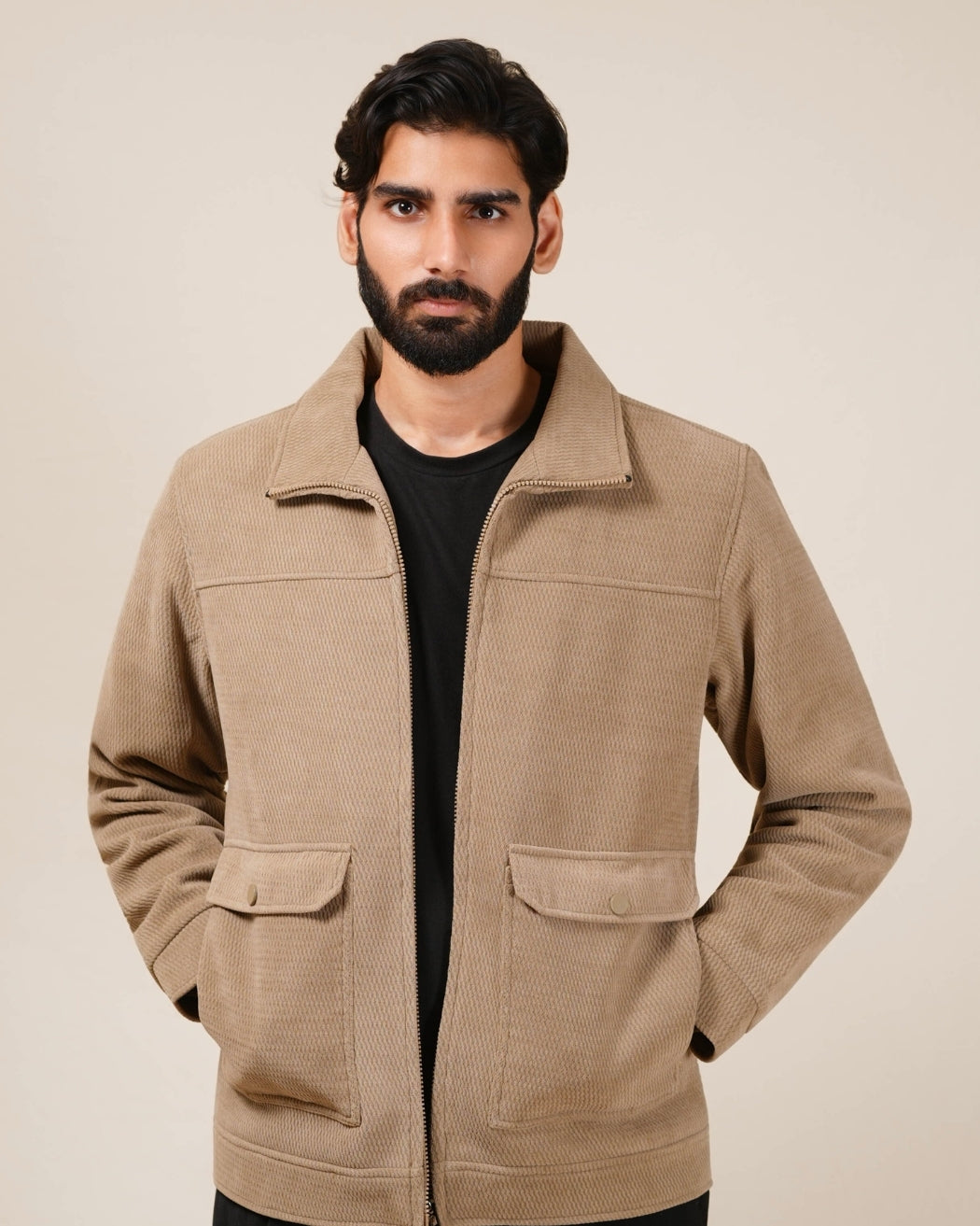 Man wearing a beige jacket against a plain background