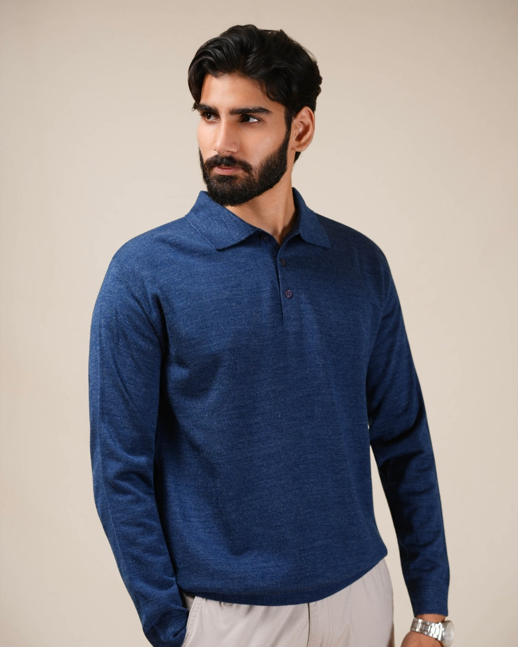 Man wearing a blue sweater against a beige background
