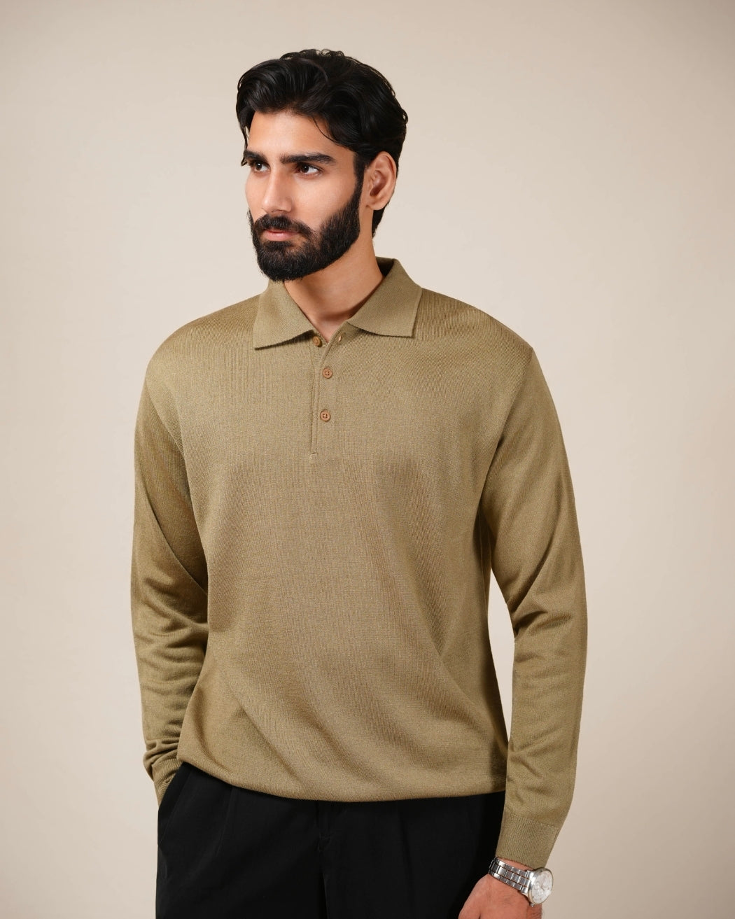 Man wearing a beige long-sleeve polo shirt against a beige background