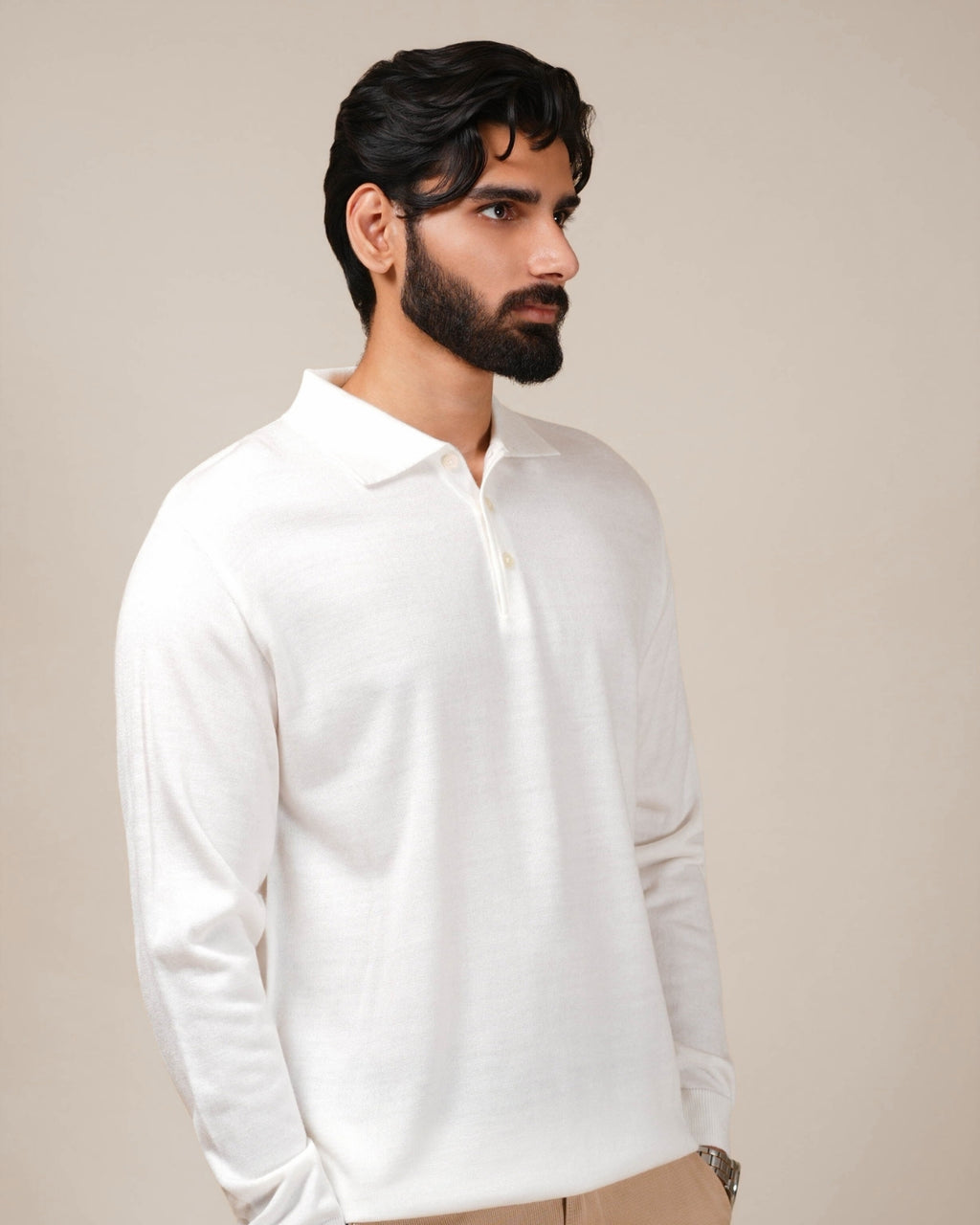 Man wearing a white long-sleeve shirt against a beige background