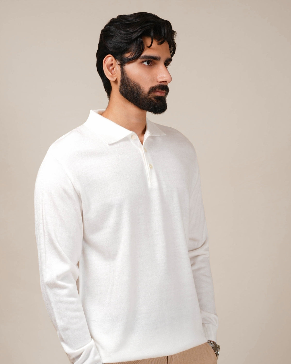 Man wearing a white long-sleeve shirt against a beige background