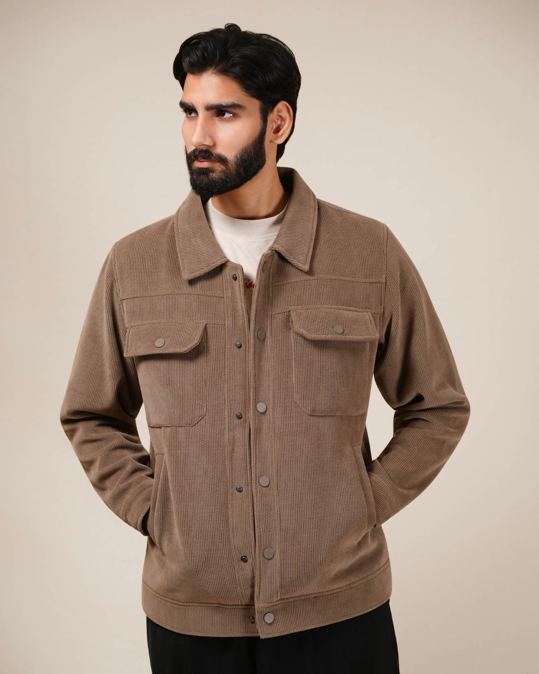 Man wearing a brown jacket against a beige background