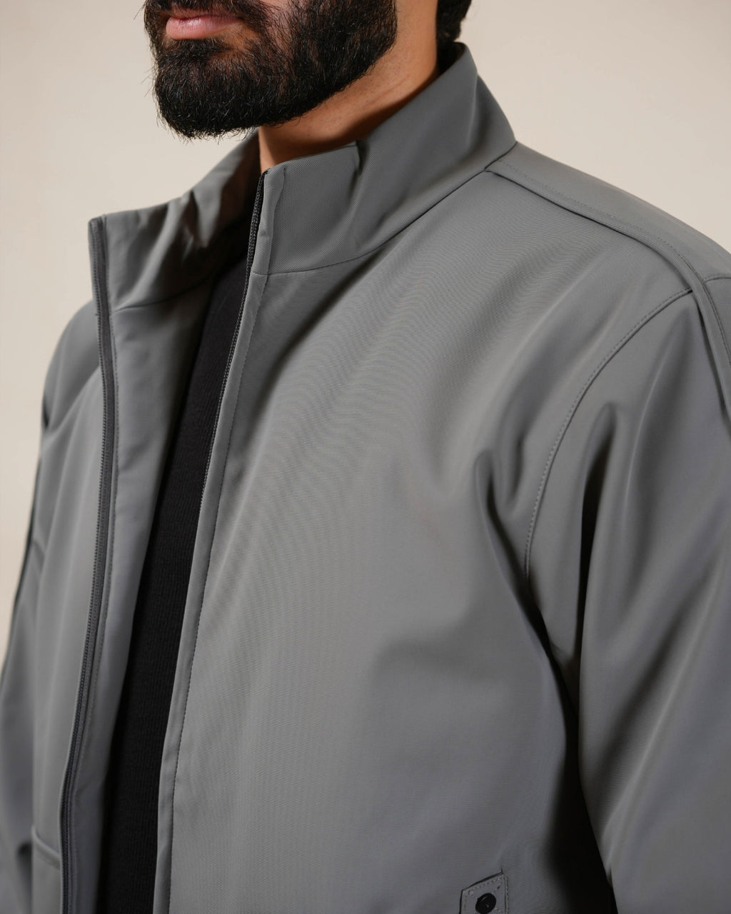 Person wearing a gray jacket with a neutral background