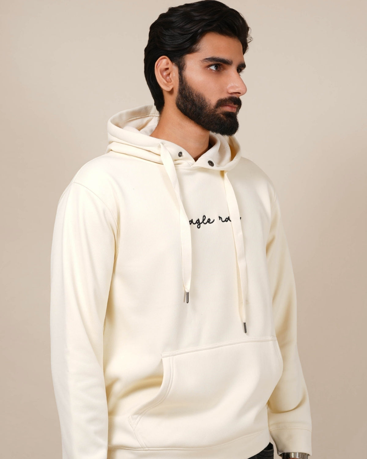 Man wearing a cream hoodie with text on a beige background