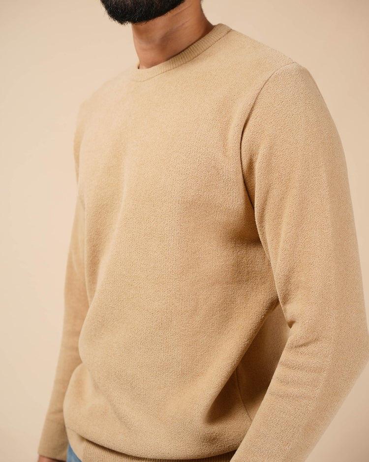 Beige sweater worn by a person on a beige background