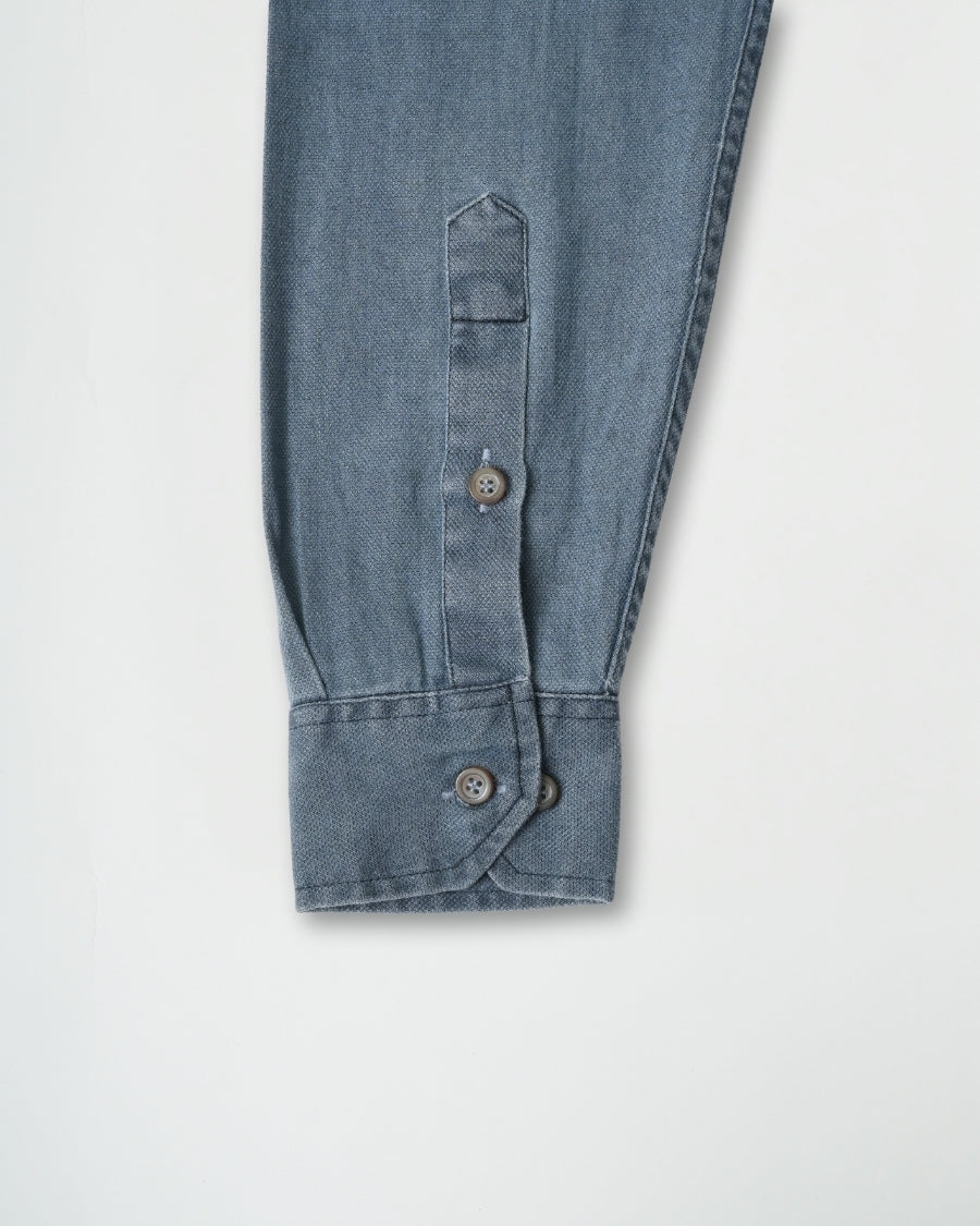Close-up of blue denim pants with button details on a white background