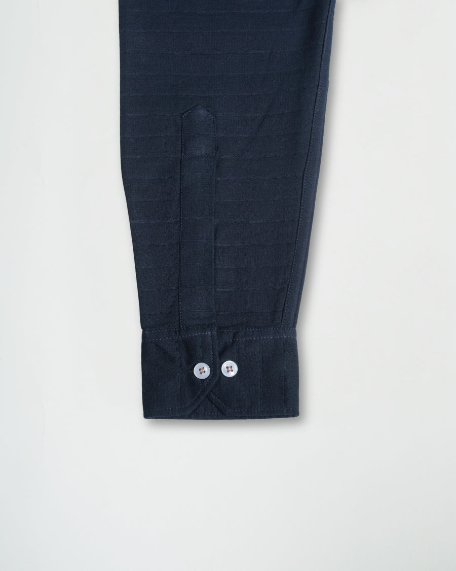 Navy blue pants with button details on a light gray background
