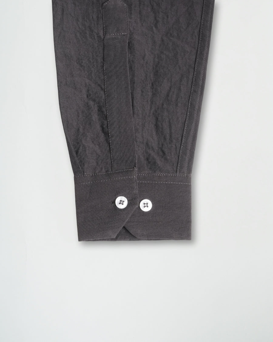 Dark gray pants with button details on a light gray background