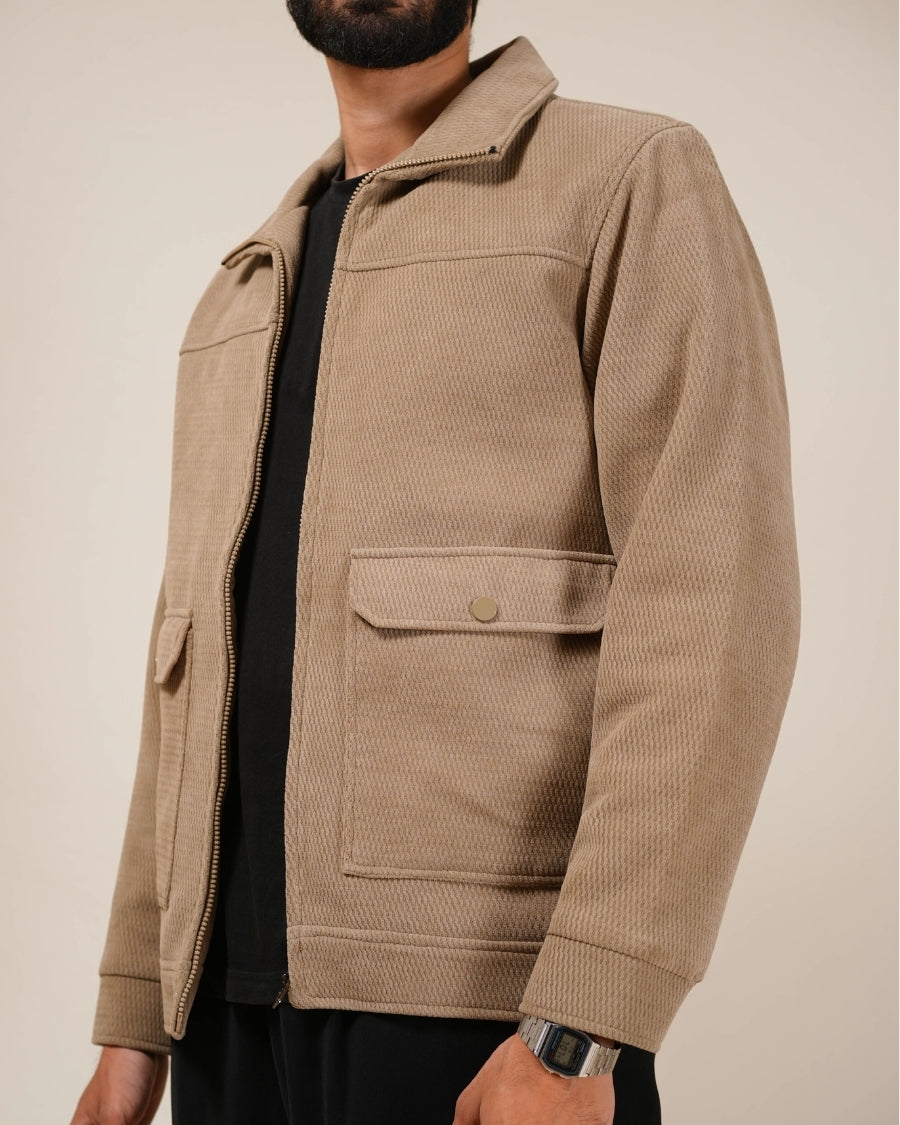 Person wearing a beige jacket with a neutral background