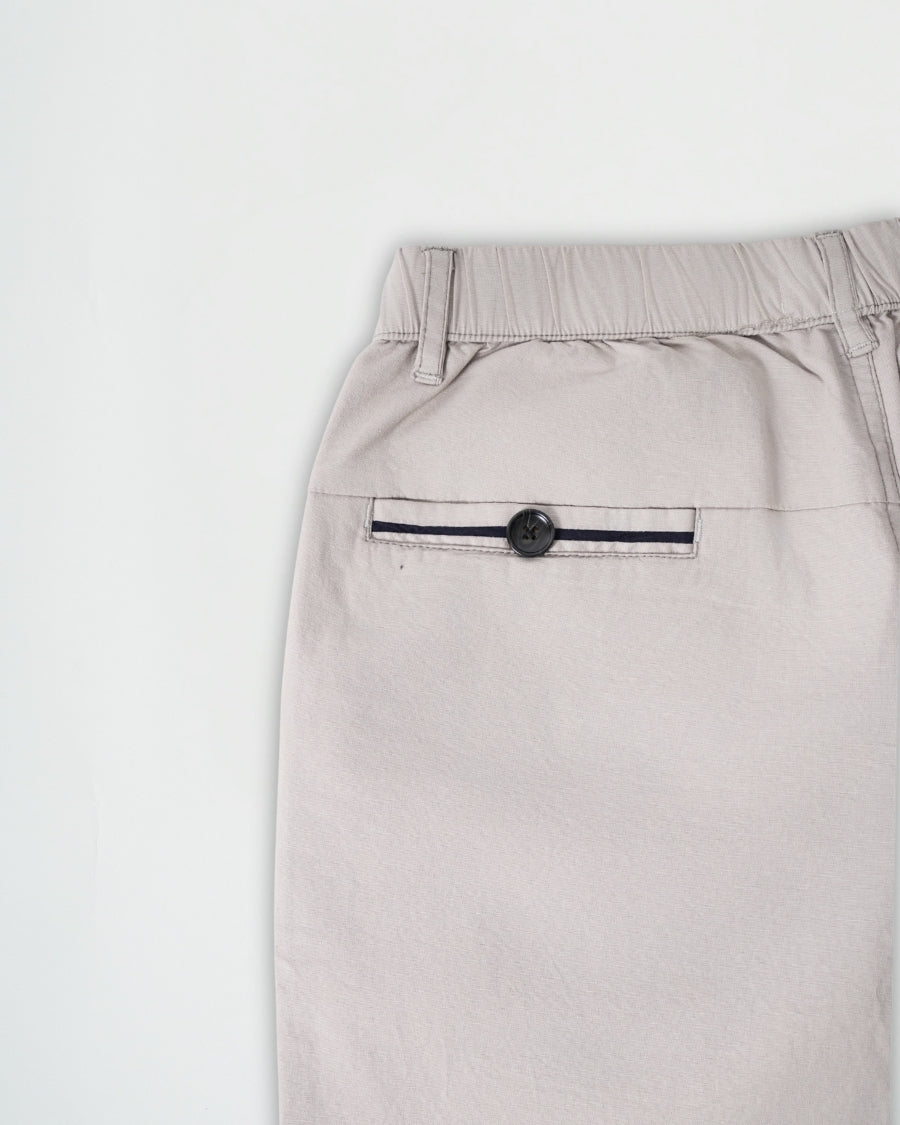 Light gray pants with a button on a white background