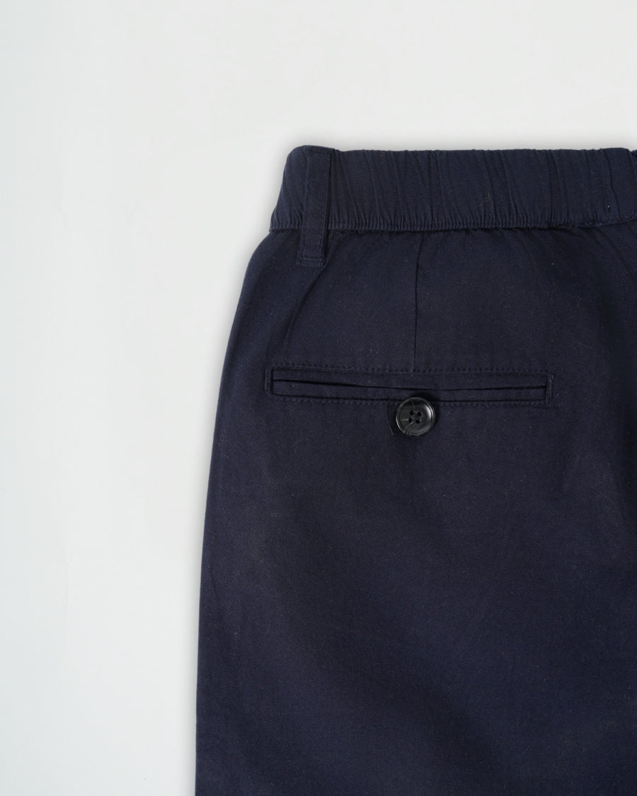 Navy blue pants with a button on a light gray background