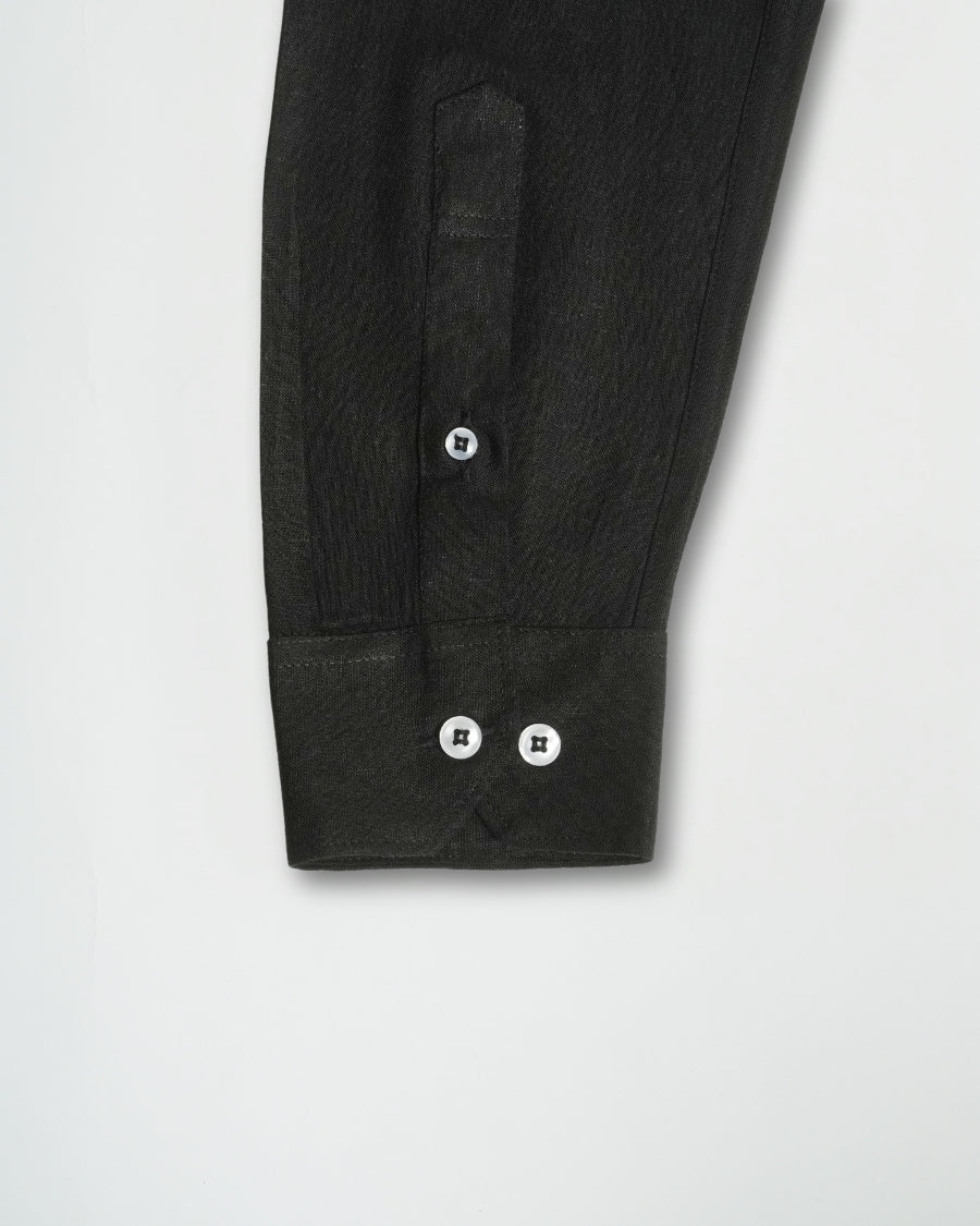 Close-up of a black shirt with button details on a light gray background