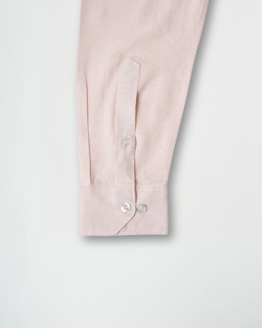 Close-up of a light pink shirt with buttons on a white background