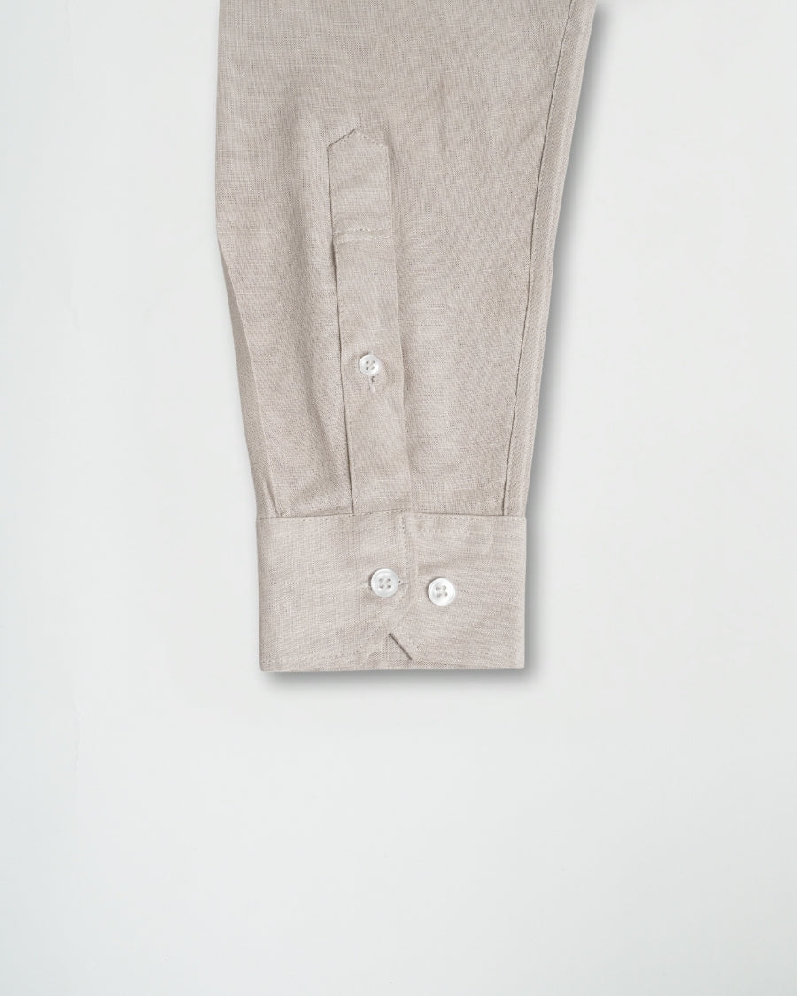Close-up of a light gray shirt with buttons on a white background