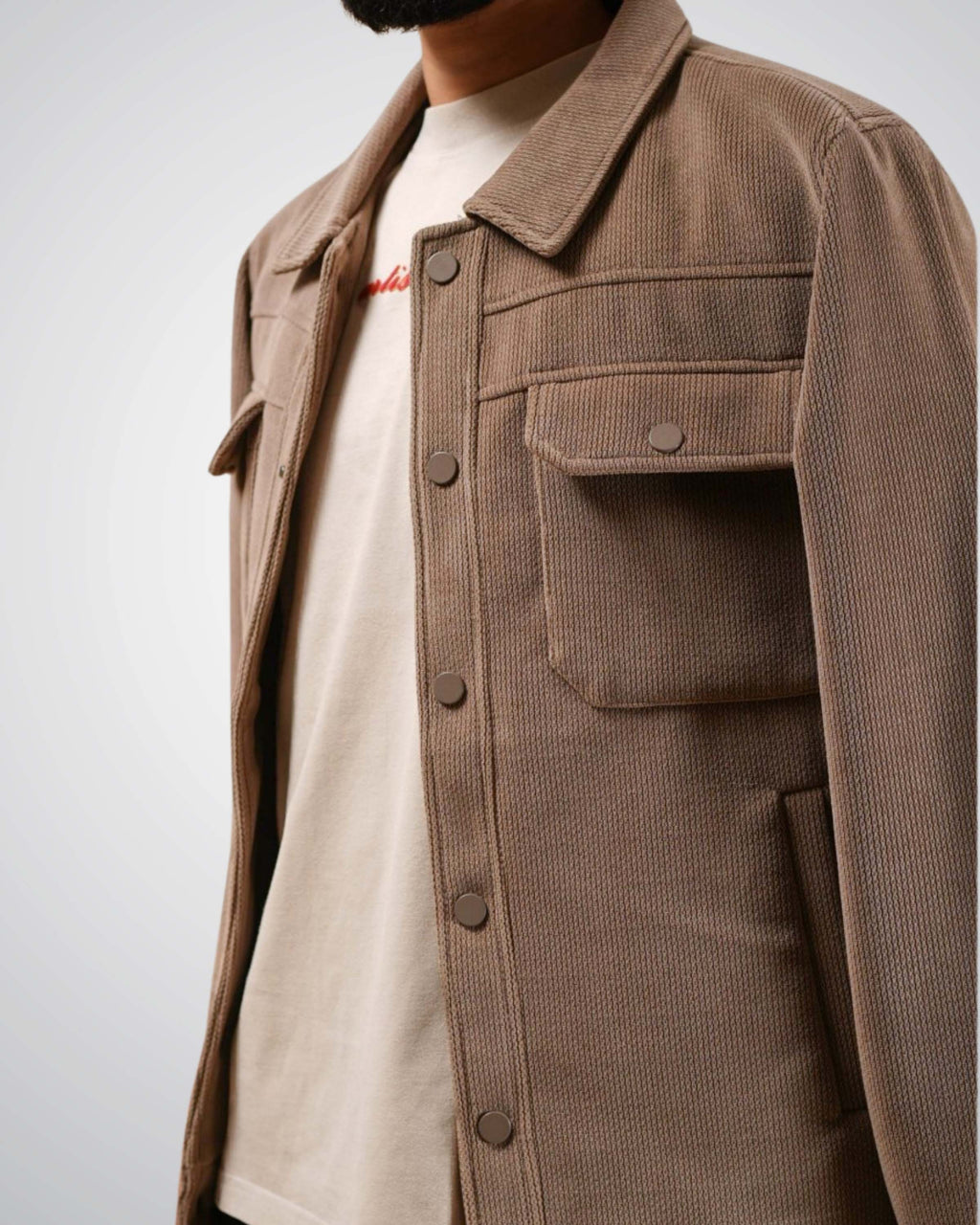 Brown jacket worn by a person on a plain background