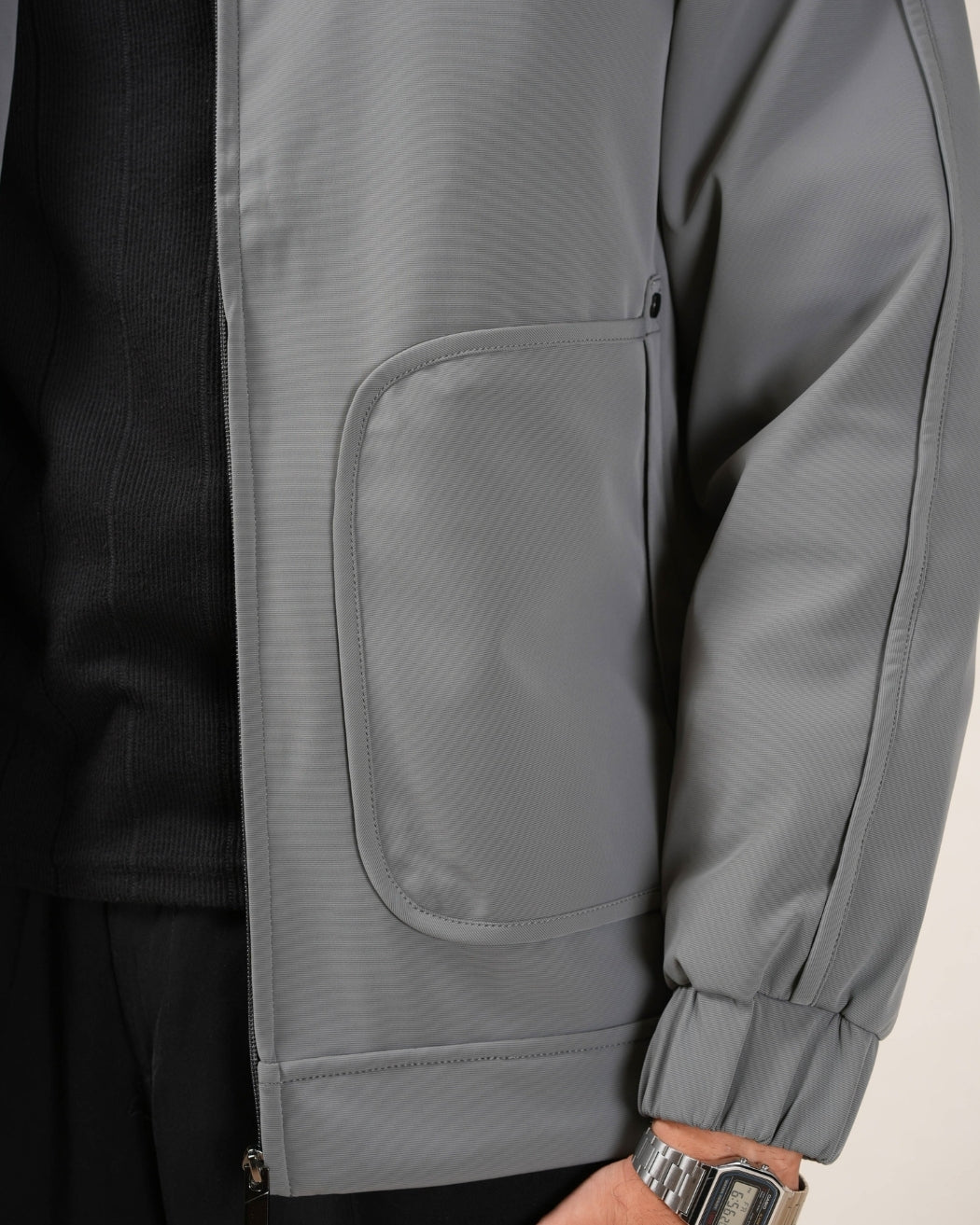 Close-up of a gray jacket with a pocket on a neutral background