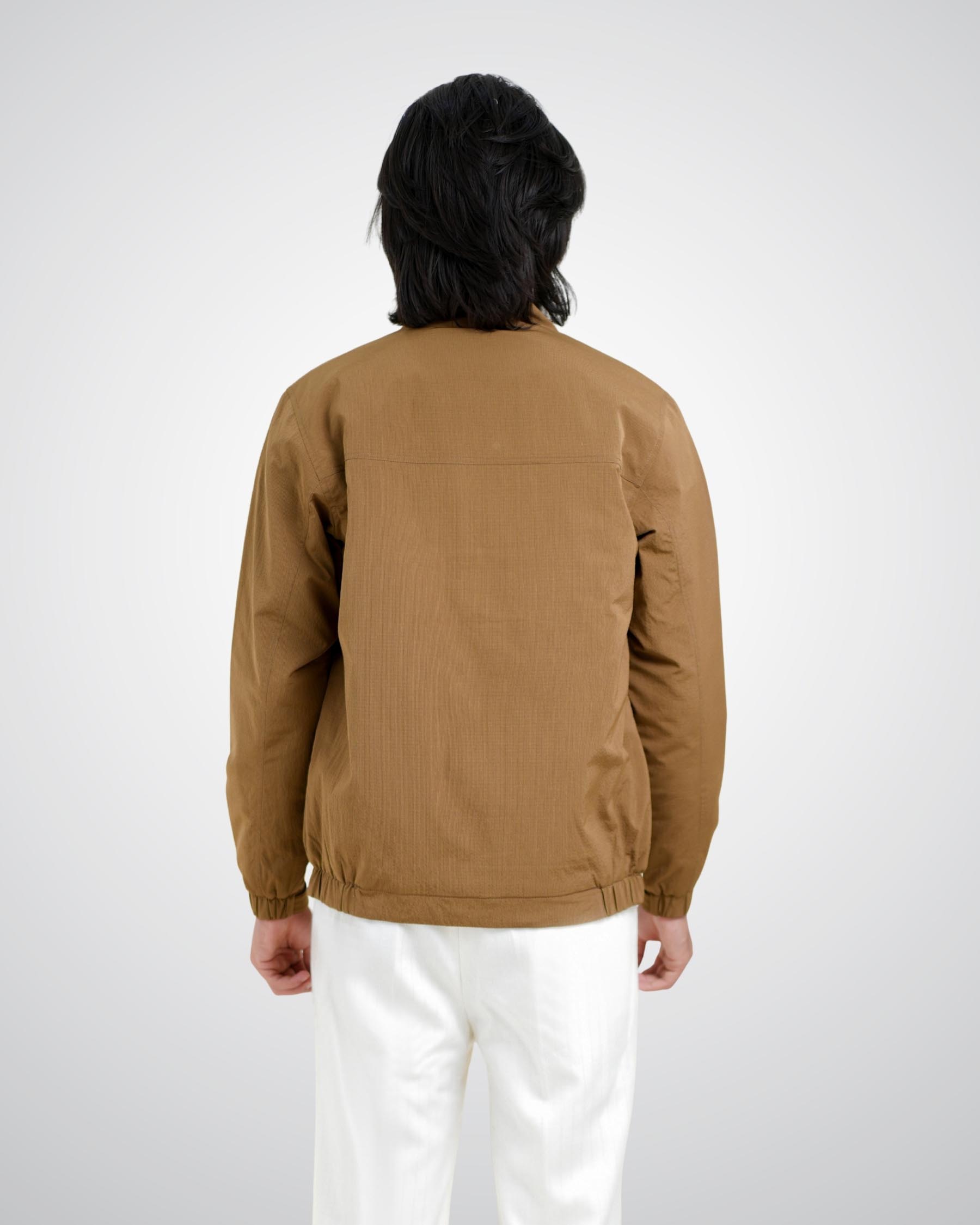 Person wearing a brown jacket on a white background