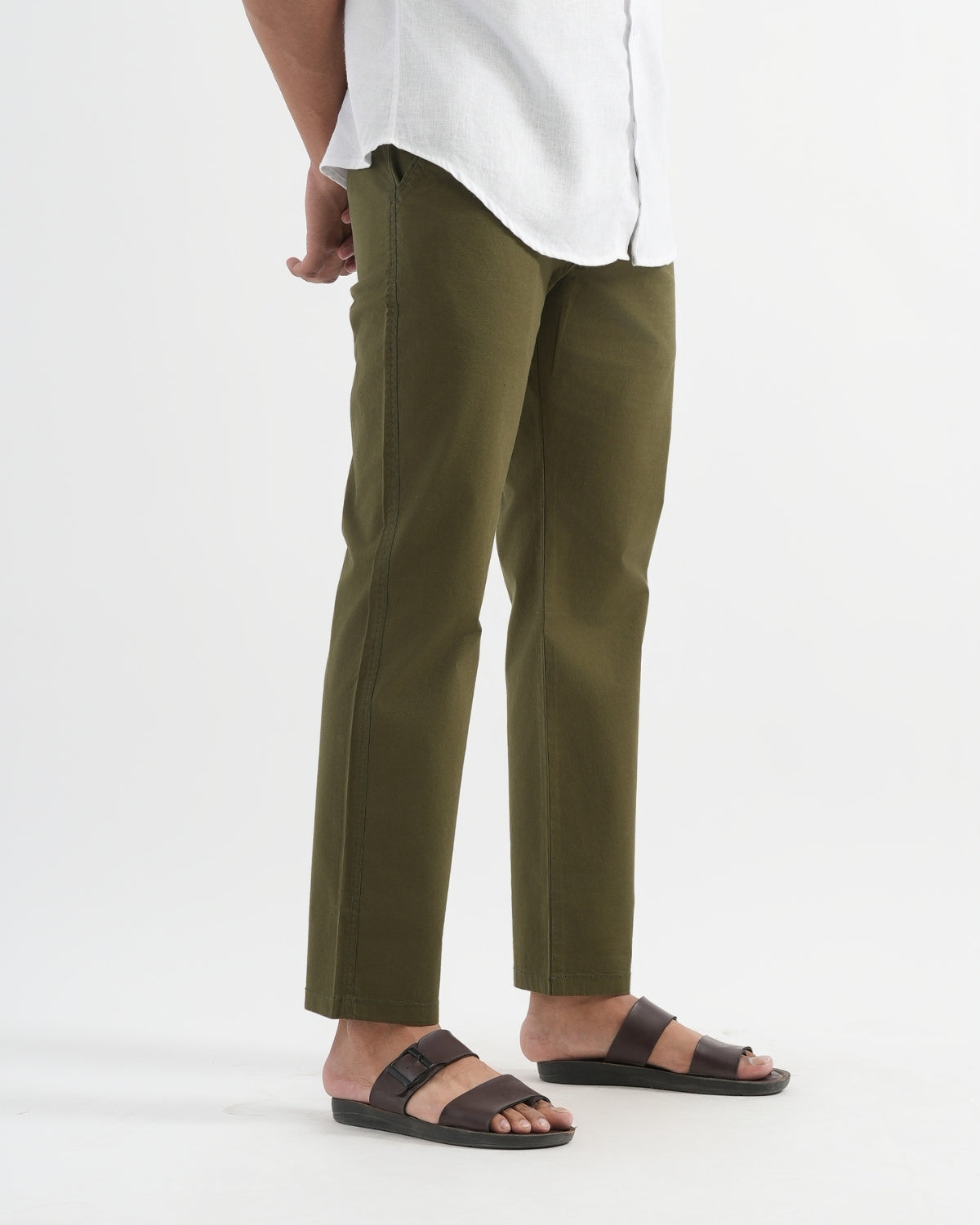 Person wearing olive green pants and white shirt on a white background