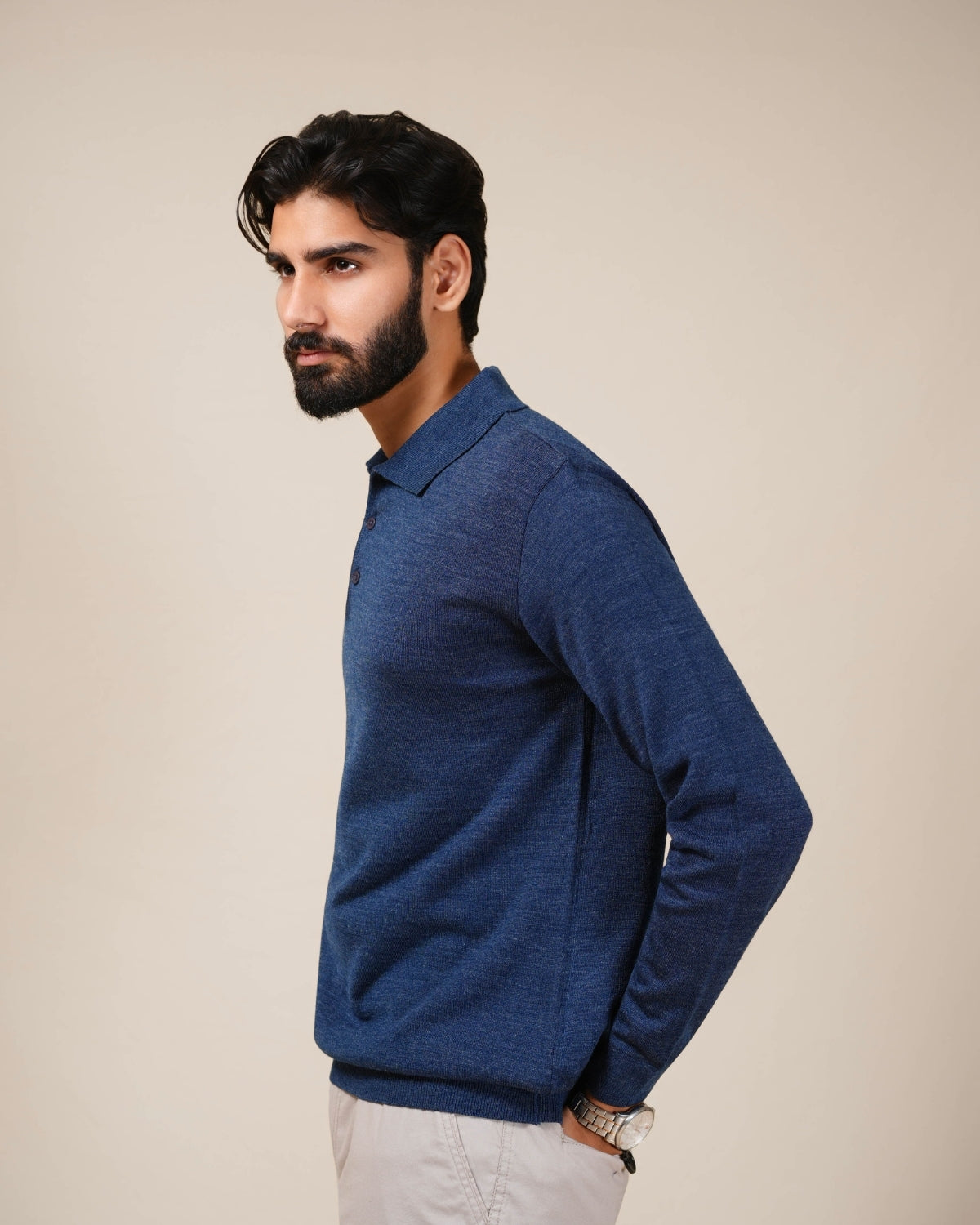Man wearing a blue sweater against a beige background