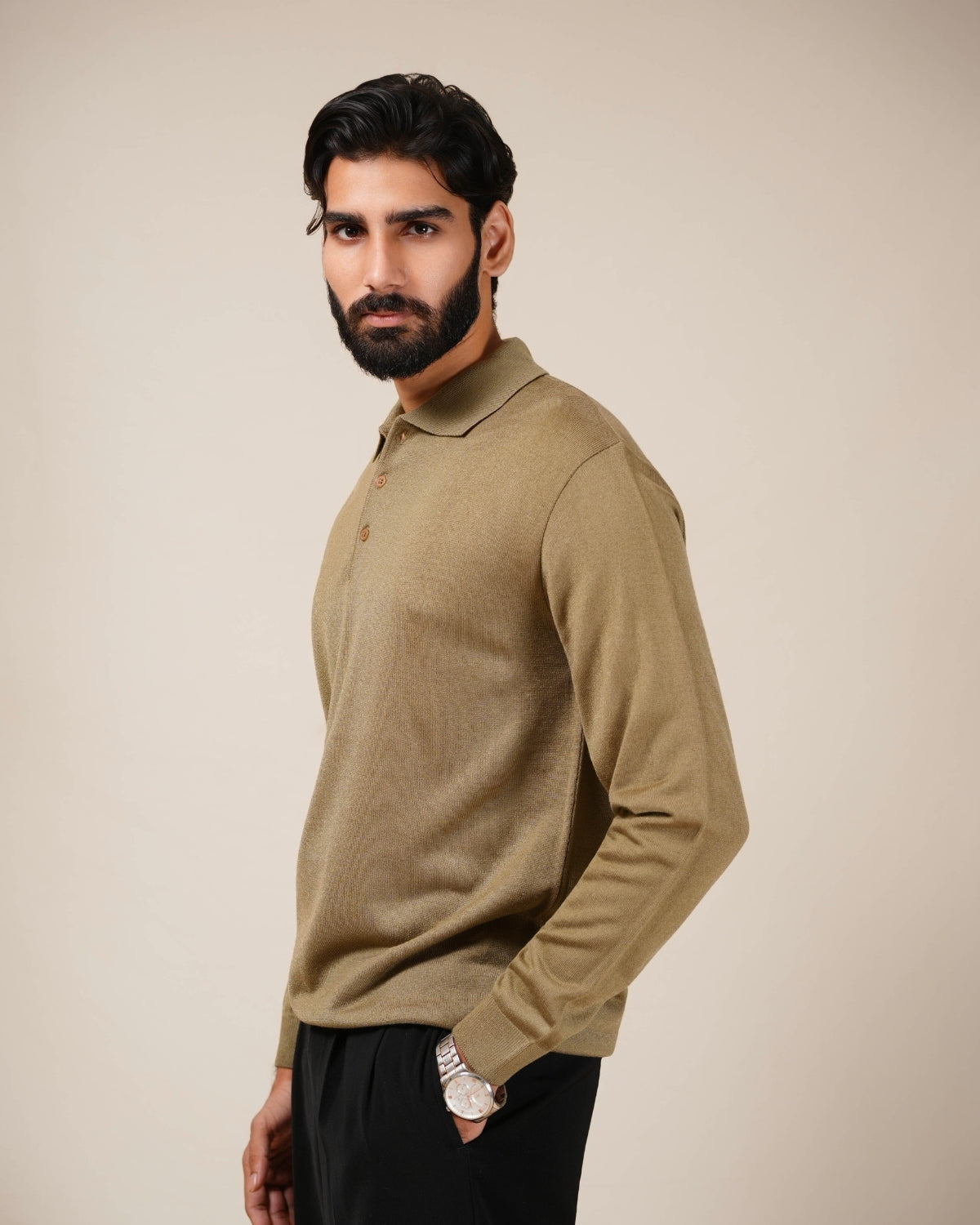 Man wearing a beige long-sleeve shirt against a beige background