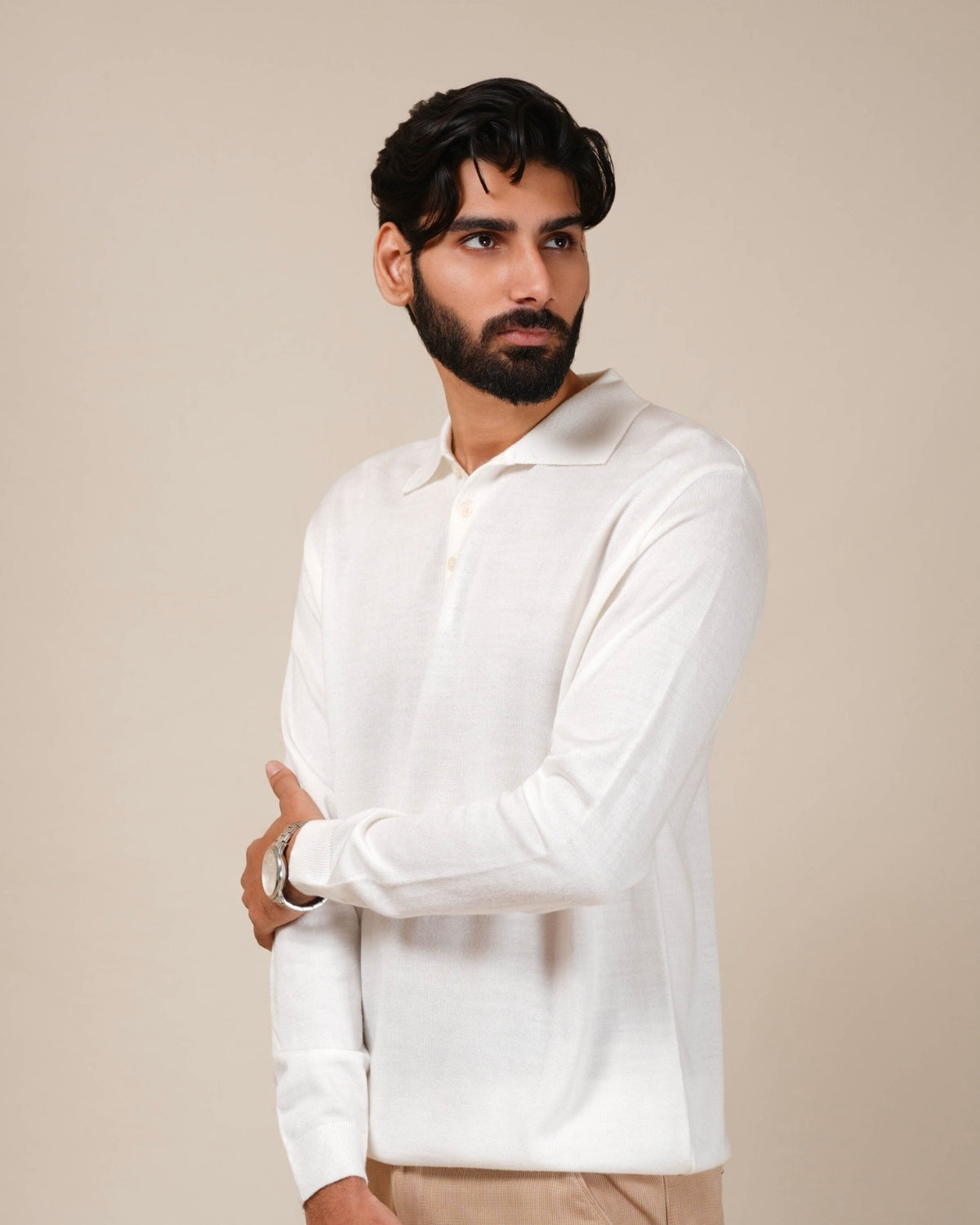 Man wearing a white long-sleeve shirt against a beige background