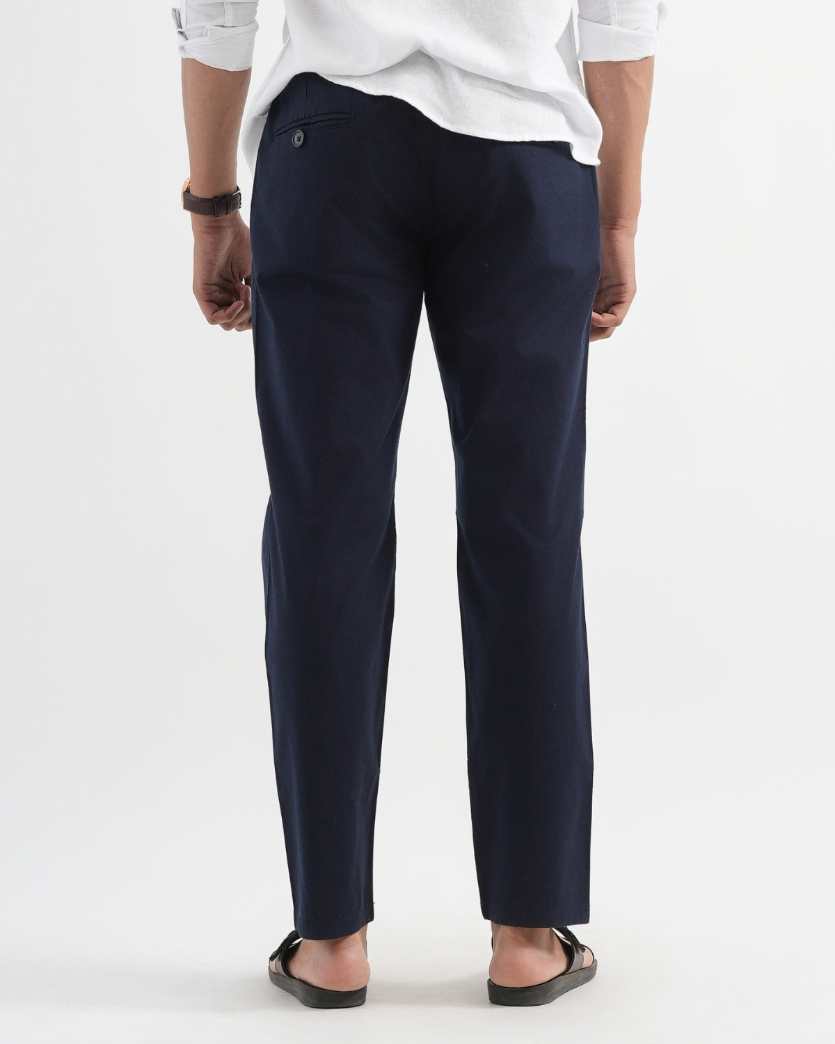 Person wearing navy pants and a white shirt on a white background