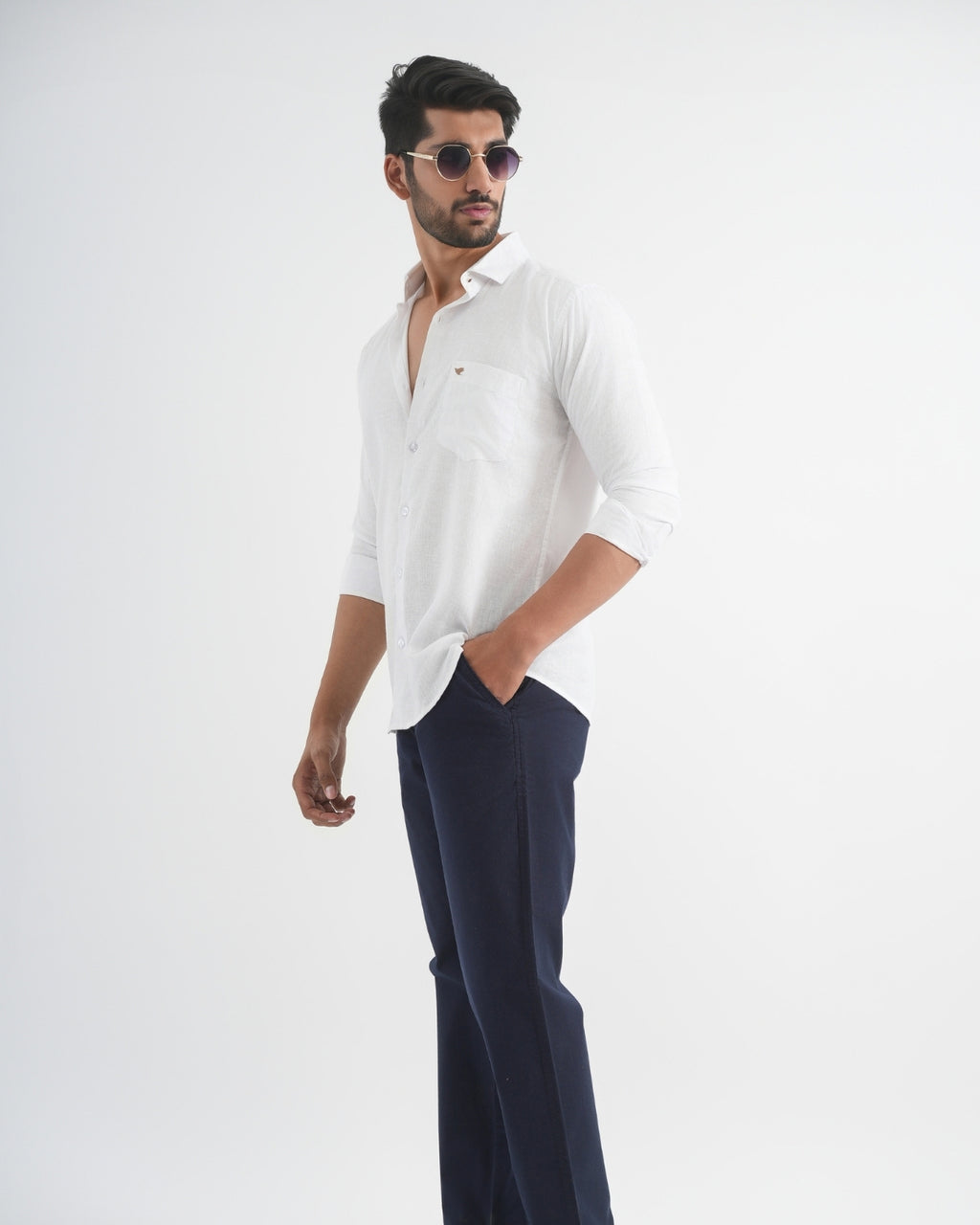 Man wearing a white shirt and dark pants on a white background