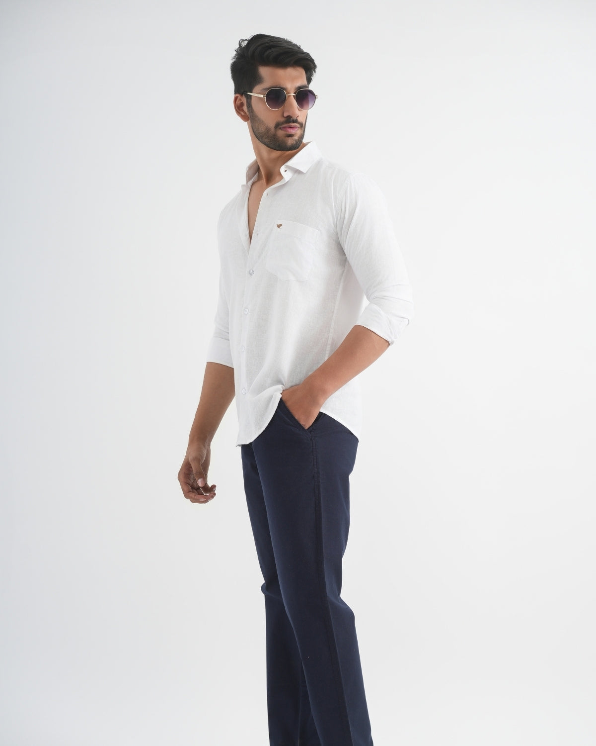 Man wearing a white shirt and dark pants on a white background