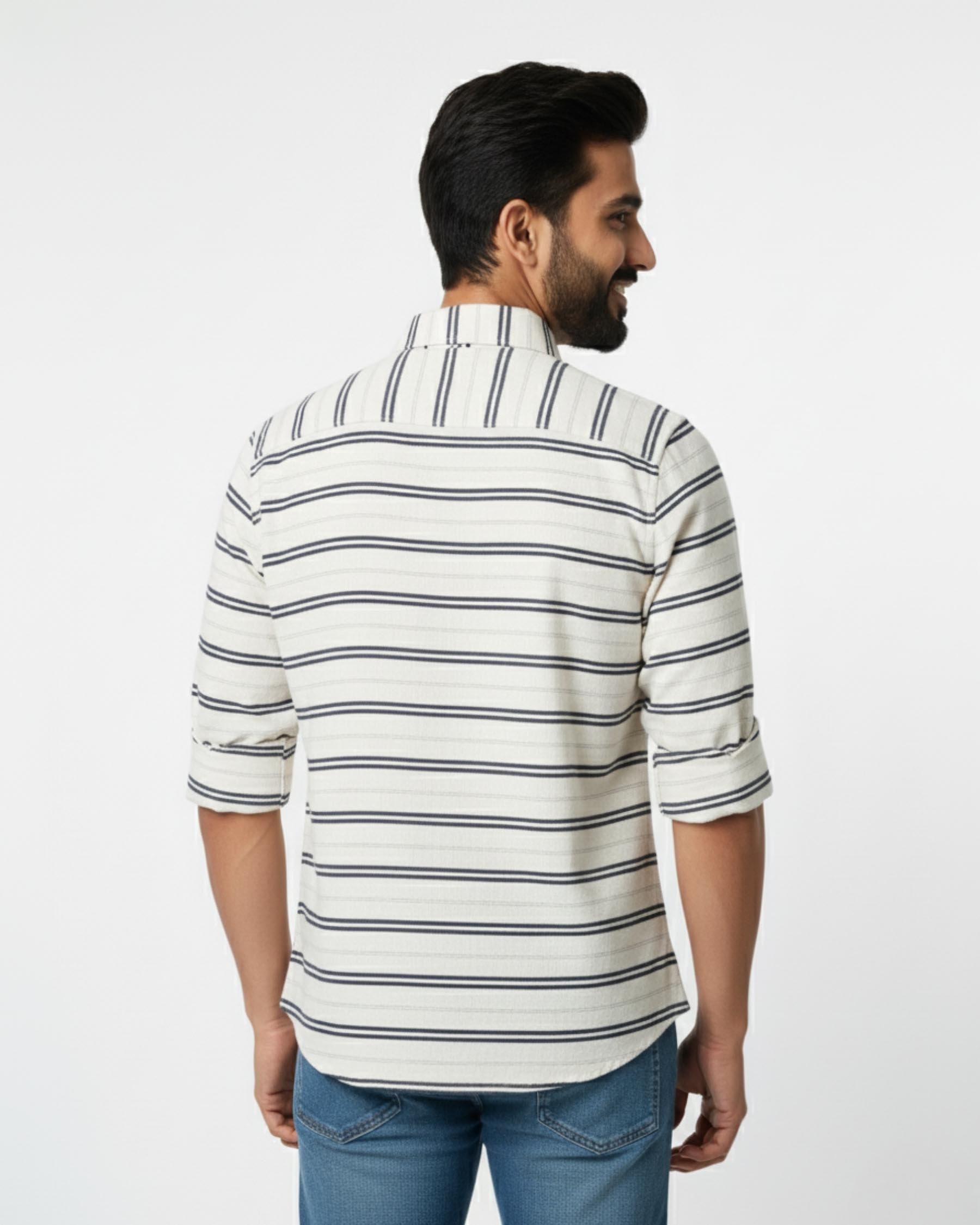 Man wearing a striped shirt and jeans on a white background